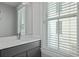 Bright bathroom featuring a large window, gray vanity, and a marble countertop at 3 1/2 Maranda Holmes St # B, Charleston, SC 29403