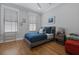 Well-lit bedroom with hardwood floors, large windows with blinds, and a comfortable bed with blue bedding at 3 1/2 Maranda Holmes St # B, Charleston, SC 29403