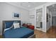 Bright bedroom featuring hardwood floors, a blue quilted bedspread, and en suite bathroom with a glass shower at 3 1/2 Maranda Holmes St # B, Charleston, SC 29403