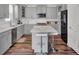 Well-lit kitchen featuring stainless appliances, gray cabinets, tile backsplash, an island with seating, and a doorway at 307 Blue Oak Dr, Moncks Corner, SC 29461