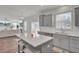 Modern kitchen with gray cabinets, stainless steel appliances, island seating, and an open floorplan to the living area at 307 Blue Oak Dr, Moncks Corner, SC 29461