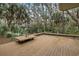 Large wooden deck with built-in seating, surrounded by palm trees and greenery at 3110 Up Da Creek Ct, Seabrook Island, SC 29455