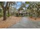 Charming home featuring a two-car garage and lush landscaping with mature trees, creating a private and inviting atmosphere at 3110 Up Da Creek Ct, Seabrook Island, SC 29455