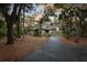 Charming home featuring a two-car garage and lush landscaping with mature trees, creating a private and inviting atmosphere at 3110 Up Da Creek Ct, Seabrook Island, SC 29455