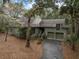 Charming home featuring a two-car garage and lush landscaping with mature trees, creating a private and inviting atmosphere at 3110 Up Da Creek Ct, Seabrook Island, SC 29455