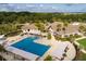 Aerial view of a swimming pool and clubhouse, surrounded by lush greenery and palm trees at 3110 Up Da Creek Ct, Seabrook Island, SC 29455