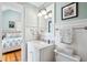 Bright bathroom features vanity with mirror, white wainscoting, and view of the bedroom, blending style and function at 34 Frogmore Rd, Mount Pleasant, SC 29464