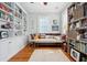 Sunlit living room with bookshelves, hardwood floors, built in cabinets, and bright windows at 34 Frogmore Rd, Mount Pleasant, SC 29464