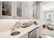Stylish wet bar area features quartz countertops, glass cabinets, sink, and beverage fridge perfect for entertaining at 34 Frogmore Rd, Mount Pleasant, SC 29464
