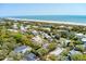 Aerial view of homes surrounded by lush greenery near the beach, showcasing a coastal residential community at 3405 Cameron Blvd, Isle of Palms, SC 29451