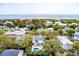 Aerial view of a coastal home with a private pool and beach access, surrounded by verdant trees and neighboring residences at 3405 Cameron Blvd, Isle of Palms, SC 29451