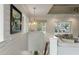 Upstairs hallway with shiplap walls leads to the living area, illuminated by hanging light fixtures at 3405 Cameron Blvd, Isle of Palms, SC 29451