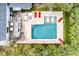 Aerial view of a backyard pool area with an outdoor seating area and lounge chairs surrounded by lush landscaping at 3405 Cameron Blvd, Isle of Palms, SC 29451