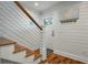 Elegant staircase with wood treads, white risers, and modern cable railing in a well-lit hallway at 3405 Cameron Blvd, Isle of Palms, SC 29451