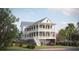 Charming two-story coastal home with double porches, lush landscaping, and convenient ground-level garage at 343 Simone Dr, Daniel Island, SC 29492