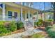 Welcoming front porch with white columns, wooden stairs, decorative flower boxes, and an American flag at 3447 Toomer Kiln Cir, Mount Pleasant, SC 29466