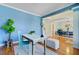 Bright home office with a desk and blue accent wall leading into an open floor plan at 3447 Toomer Kiln Cir, Mount Pleasant, SC 29466