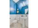 Stylish powder room with blue walls, white wainscoting, a pedestal sink, and decorative mirror at 3447 Toomer Kiln Cir, Mount Pleasant, SC 29466