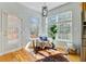 Bright sunroom with large windows, cozy seating, and ample sunlight on hardwood flooring at 3447 Toomer Kiln Cir, Mount Pleasant, SC 29466