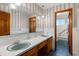 Vintage bathroom featuring dual sinks, floral wallpaper, patterned flooring, and a separate tub at 4322 Bream Rd, North Charleston, SC 29418