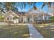 Charming brick home featuring a covered porch, mature trees, and a well-manicured front yard at 4322 Bream Rd, North Charleston, SC 29418