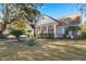 Charming brick home with a welcoming front porch, beautiful trees, and lush green lawn at 4322 Bream Rd, North Charleston, SC 29418