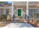 Welcoming front porch featuring brick columns, a green front door and a cozy seating area at 4322 Bream Rd, North Charleston, SC 29418