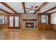 Spacious living room featuring wood beams, a brick fireplace, built-in shelving, and gleaming hardwood floors at 4322 Bream Rd, North Charleston, SC 29418