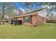 A backyard with a brick house, a grill, and a large tree providing ample shade on a bright, sunny day at 462 Mount Royall Dr, Mount Pleasant, SC 29464