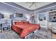 Bedroom with blue walls, a ceiling fan, a bed with red floral bedding, bedside tables, and an open bathroom at 462 Mount Royall Dr, Mount Pleasant, SC 29464