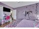 A bedroom features purple walls, a ceiling fan, a bed with floral bedding, and a desk with a pink chair at 462 Mount Royall Dr, Mount Pleasant, SC 29464