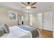 Comfortable bedroom with hardwood floors, a ceiling fan, and views to a bathroom and closet at 4757 June St, North Charleston, SC 29405
