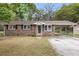 Charming brick home with a covered parking, well-maintained lawn, and mature trees at 4757 June St, North Charleston, SC 29405