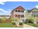 Charming red two-story home with a two-car garage, balconies, manicured lawn, and a private driveway at 490 Sanders Farm Ln, Charleston, SC 29492