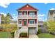 Inviting two-story red home with a front-facing two-car garage and white columns on dual balconies at 490 Sanders Farm Ln, Charleston, SC 29492