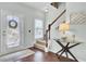 Welcoming foyer with glass front door, hardwood floors, staircase, and decorative glass-top table at 490 Sanders Farm Ln, Charleston, SC 29492