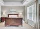 This well-lit main bedroom features neutral carpet, a tray ceiling, and a dark wood sleigh bed with matching furniture at 490 Sanders Farm Ln, Charleston, SC 29492