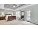 Main bedroom with neutral carpet, tray ceiling, windows for natural light, and dark wood bedroom furniture at 490 Sanders Farm Ln, Charleston, SC 29492