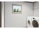 Bright laundry room features a window, shelving, and a white front-loading washer and dryer set at 525 Railed Ridge Way, Moncks Corner, SC 29461