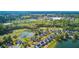 Aerial view of homes surrounding a lake and golf course, with a town center visible in the distance at 5254 Mulholland Dr, Summerville, SC 29485