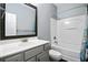 Well-lit bathroom with single sink vanity, framed mirror, and tub with shower at 5254 Mulholland Dr, Summerville, SC 29485