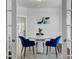 Bright dining room featuring a modern white table, blue velvet chairs, and elegant decor at 5254 Mulholland Dr, Summerville, SC 29485