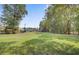 Expansive green lawn surrounded by mature trees, perfect for outdoor activities at 5254 Mulholland Dr, Summerville, SC 29485