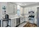 A well-lit kitchen featuring stainless steel appliances, white cabinets, and quartz countertops at 5254 Mulholland Dr, Summerville, SC 29485