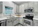 Bright kitchen features white cabinets, granite countertops, stainless steel appliances, and tiled backsplash at 5254 Mulholland Dr, Summerville, SC 29485