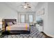 Spacious main bedroom with a gray headboard bed, patterned rug, ceiling fan and bright windows at 5254 Mulholland Dr, Summerville, SC 29485