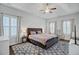 Spacious main bedroom with a gray headboard bed, patterned rug, ceiling fan and bright windows at 5254 Mulholland Dr, Summerville, SC 29485