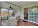 Covered porch with ceiling fan and furniture; slider leads to the home's interior at 5254 Mulholland Dr, Summerville, SC 29485