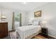 Bright bedroom with white bed, side tables, lamps, neutral walls, and a patterned rug at 5638 Dixie Plantation Rd, Hollywood, SC 29449