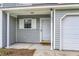 Townhome front porch with white trim, modern door, window, and attached garage at 601 Buckthorn Cir, Summerville, SC 29483